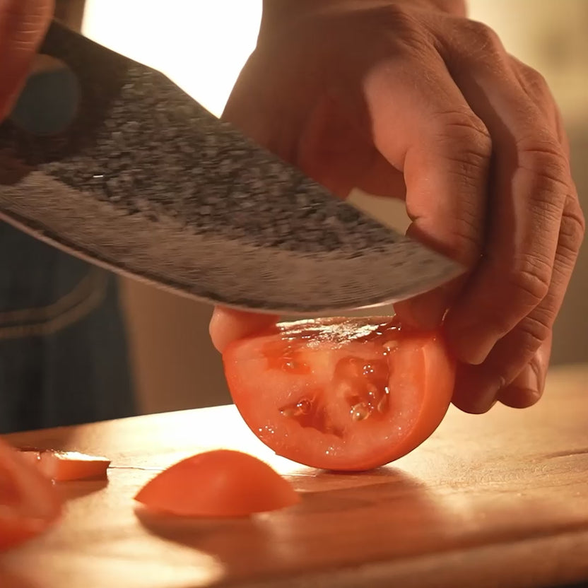 Close-up of chef's hand using the Matsato Osuren finger hole during cutting